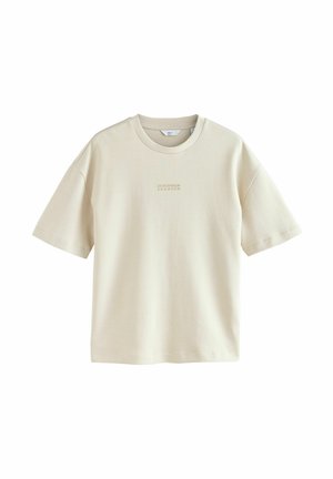 Camiseta de manga corta color beige claro, fabricada con un material suave. Presenta un sutil patrón a rayas y un pequeño logo impreso en el pecho.