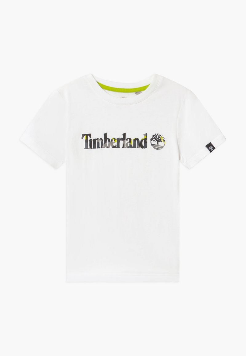 T-shirt en coton blanc avec le logo "Timberland" en noir et vert, col rond et manches courtes avec un accent noir sur la manche.