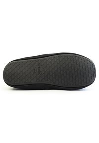 Suela de zapato negra con goma texturizada, que presenta una superficie de agarre estampada y una impresión de logo. Bisel superior liso sin costuras ni acentos visibles.