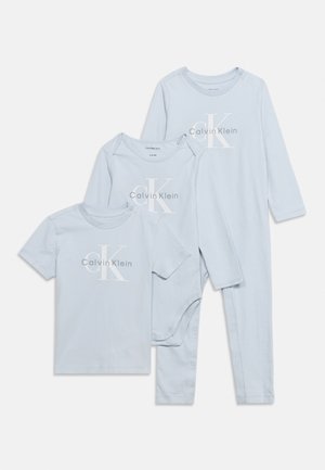 Tri svetlomodré kúsky detského oblečenia Calvin Klein: tričko s krátkym rukávom, body s dlhým rukávom a dlhý overal bez nožičiek so zapínaním na patentky.