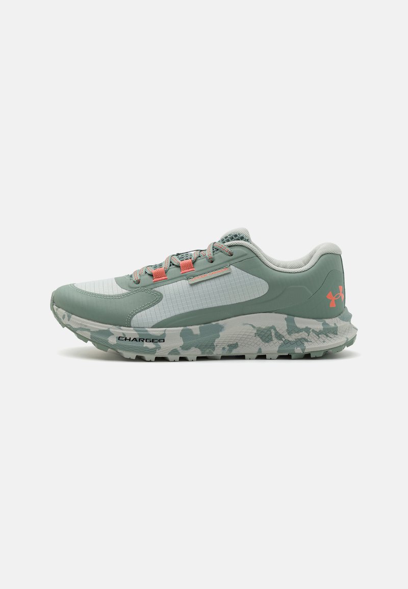 Scarpe da corsa verde chiaro con una tomaia testurizzata, pannelli in rete, dettagli rosa e una suola con motivo camouflage etichettata "CHARGED".