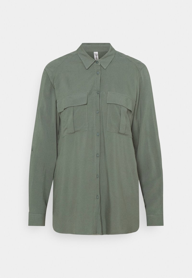 Chemise boutonnée à manches longues de couleur vert olive, avec col et deux grandes poches poitrine à rabats.