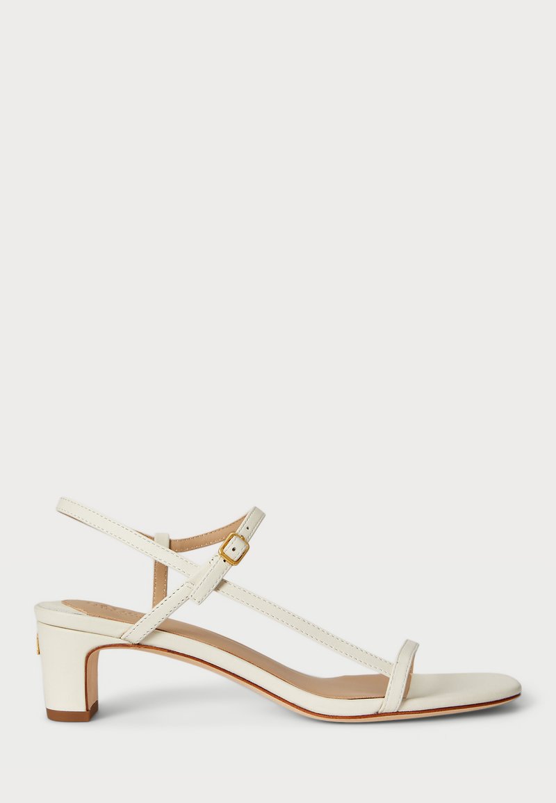 Valge nahast sandaal madala plokkmuhviga, millel on õhukesed rihmad ja pannal. Sile tekstuur ja minimalistlik disain.
