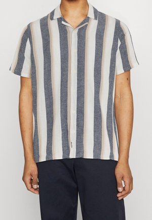 Camicetta a maniche corte con bottoni, a strisce verticali blu navy, beige e bianche, realizzata in tessuto leggero. Presenta un design con colletto da campeggio.