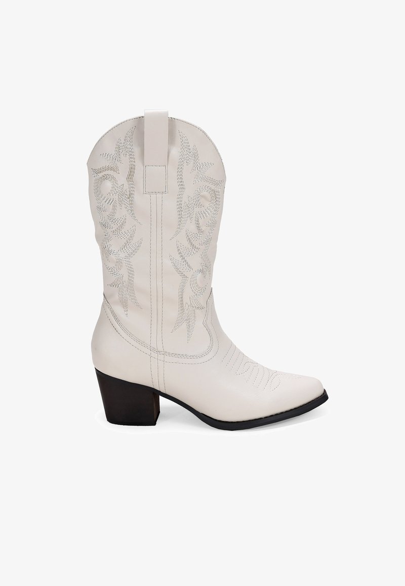 Bota de vaquero de cuero blanca con patrones decorativos bordados, puntera afilada y un tacón cuadrado de altura media. Tirador en la parte superior para facilitar su uso.