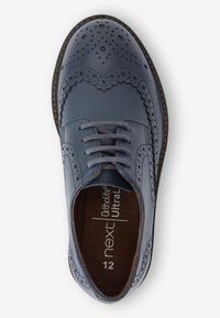 Scarpa brogue in pelle blu con perforazioni decorative, design con lacci, soletta ortolite e suola texturizzata marrone. Vista dall'alto.