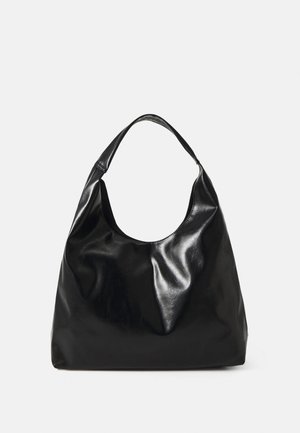 Schwarze glänzende Lederschultertasche mit breitem Einzelriemen und einem lässigen, leicht zerknitterten Körper vor einfarbigem Hintergrund.