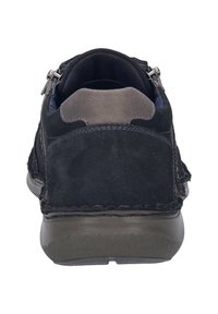 Mustat mokka kengät harmailla yksityiskohdilla, pyöreällä muotoilulla, sileällä pinnalla, takakappaleen vetoketjuyksityiskohdalla ja erottuvalla ompelemisella pohjassa.