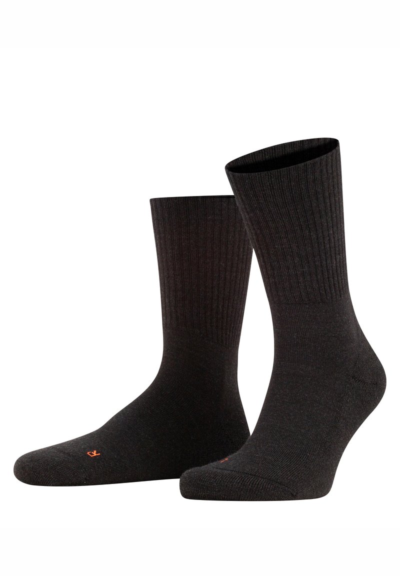 Meias pretas caneladas com textura suave, comprimento até metade da canela, biqueiras reforçadas e costura subtil em laranja no punho.