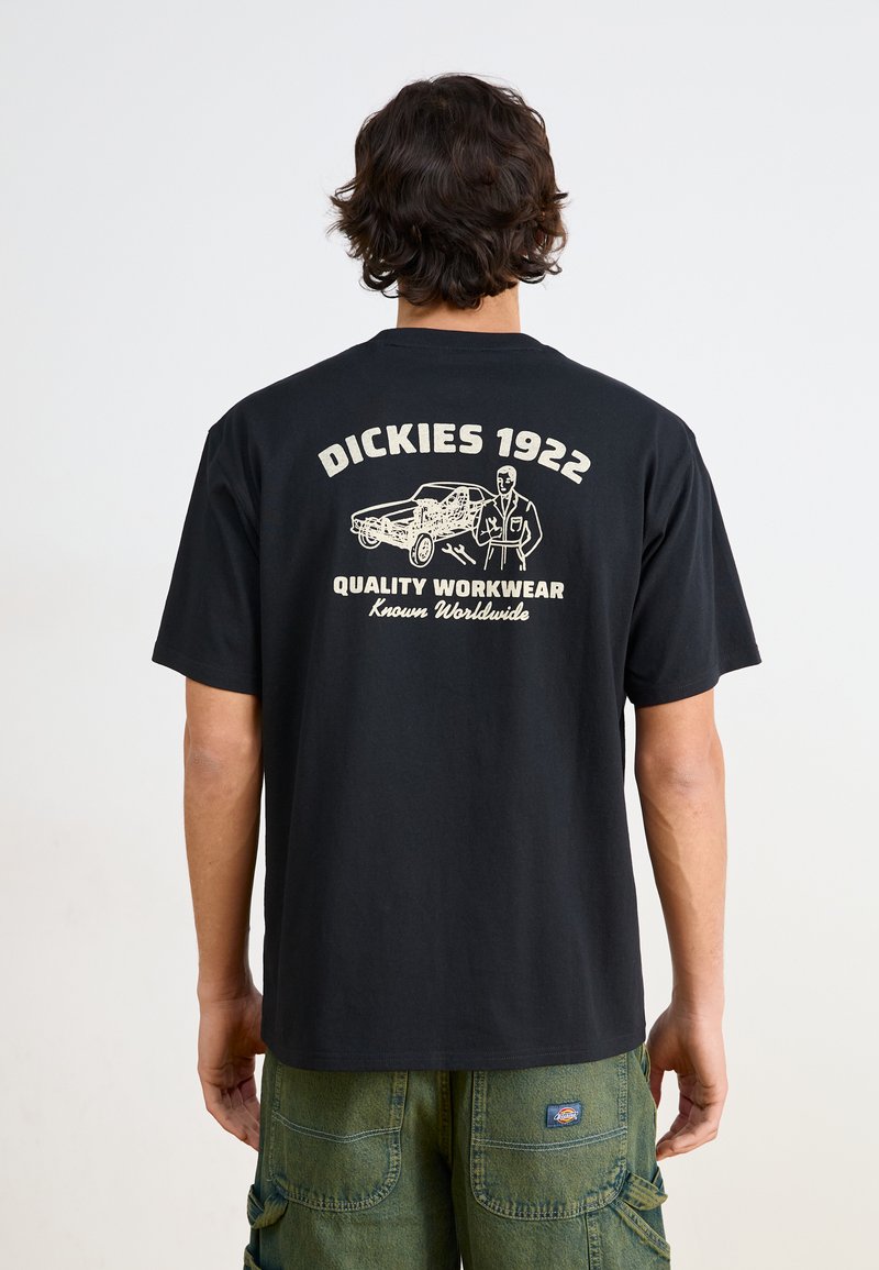 Svart bomulls t-skjorte med hvit grafisk tekst og illustrasjoner på baksiden. Korte ermer og klassisk rund halsdesign.
