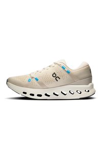 Scarpa da corsa beige con tomaia in mesh, accenti blu e suola nera. Presenta una suola intermedia spessa con ritagli per l'ammortizzazione e la ventilazione.