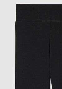 Czarne legginsy wykonane z miękkiego, elastycznego materiału; wyposażone w szeroki elastyczny pas i gładką teksturę bez widocznych szwów czy wzorów.