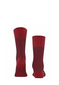 Calzini rossi con un motivo a zig-zag, caratterizzati da un bordo e un tallone rosso a coste. Realizzati in tessuto morbido ed elasticizzato per il massimo comfort.