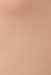 Tessuto elastico beige, caratterizzato da una fine texture a coste con linee diagonali, superficie liscia e un aspetto leggero.
