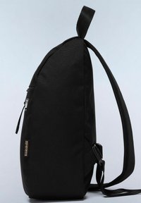 Sac à dos en tissu noir avec un profil étroit, doté d'une poche zippée latérale, de bretelles réglables et d'une poignée de transport supérieure.