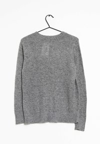 Maglione grigio a maniche lunghe, in maglia, appeso a una gruccia nera su uno sfondo bianco, visto da dietro.