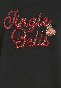 Svart tyg med röd paljettext "Jingle Bells" och en liten dekorativ klocka med rutigt mönster och rosett.