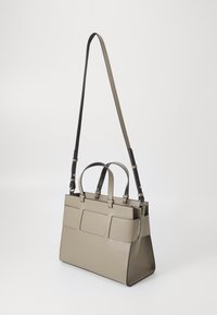 Borsa in pelle beige con accenti neri, due manici superiori e una tracolla staccabile. Presenta diversi scomparti frontali e un design strutturato.