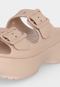 Sandale à plateforme beige avec deux brides réglables à boucle et semelle texturée, conçue pour un usage décontracté et le confort.