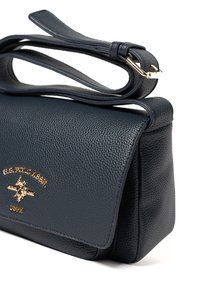 Borsa a spalla in pelle blu navy con finitura testurizzata, ferrature dorate e chiusura a patta. Dotata di tracolla removibile per versatilità.