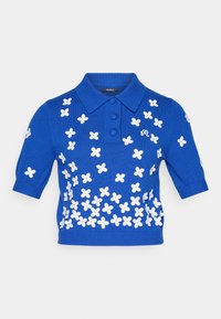 Kortermet blå polo-skjorte med teksturert strikk, med hvit blomsterbroderi og treknappeåpning.