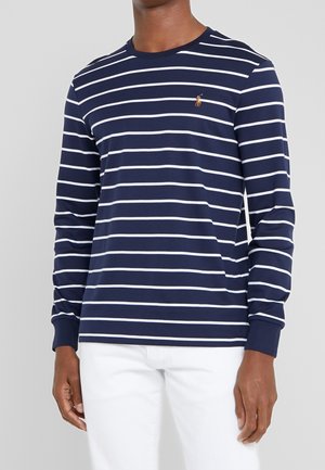 Marineblaue Langarmbluse mit weißen horizontalen Streifen, runder Halsausschnitt und gesticktem Logo auf der Brust. Baumwollmaterial mit glatter Textur.
