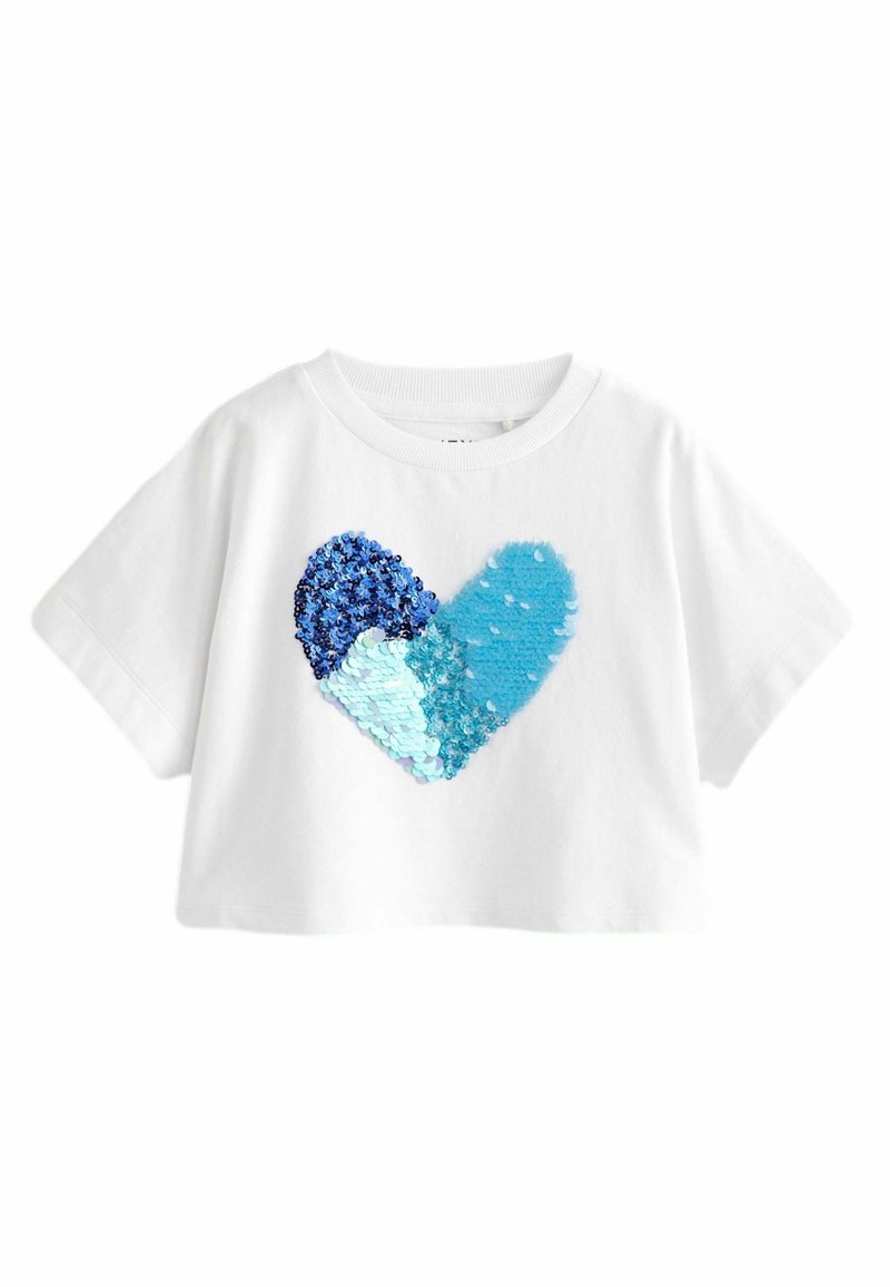 Vit kortärmad croppad t-shirt med ett hjärtmotiv gjort av blå och akvamarina paljetter som glittrar i olika ljusvinklar.