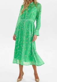 Grön långärmad klänning i genomskinligt tyg med blommönster i rosa och vitt. Inkluderar ett knytbälte och knappstängning.