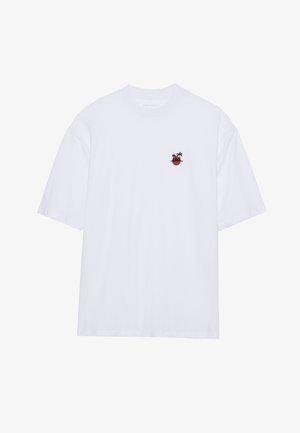 Bijela pamučna majica s kratkim rukavima, s malim izvezenim dizajnom crvenog lonca s dva palmina drveta na prsima.