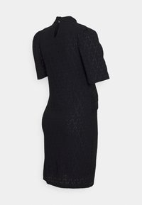 Vestido preto ajustado feito de tecido texturizado com padrão de diamante, mangas curtas em formato de puff e fechamento nas costas em forma de buraco chave.