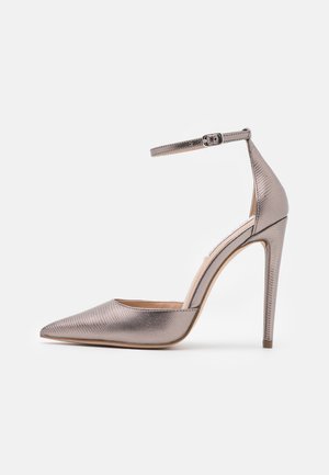 Spidse højhælede sko med en metallisk rosa guldfinish, tekstureret overflade, ankelrem med spænde og slank stilettho.