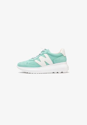 Zapatilla verde menta con cordones blancos, suela blanca gruesa y un gran logo blanco "N" en el lateral.