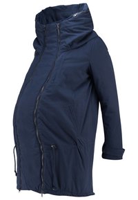 Manteau de maternité bleu marine avec col montant, panneau avant allongé, deux poches verticales zippées et cordons ajustables à l'ourlet.