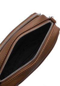 Borsa in pelle marrone con due cerniere argentate, caratterizzata da una superficie testurizzata e una foderatura interna nera. Si apre ampiamente per un facile accesso.