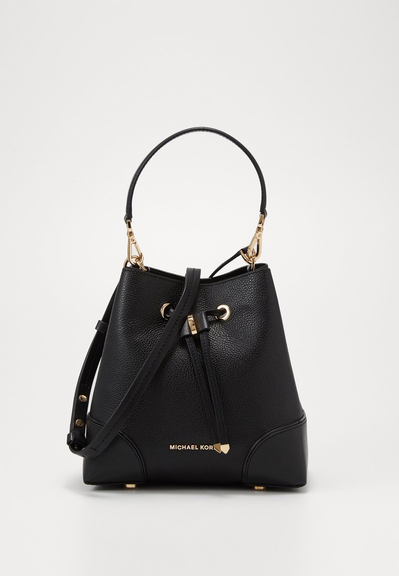 Sac seau en cuir grainé noir avec ferrures dorées, fermeture à cordon, poignée supérieure, bandoulière réglable, et logo Michael Kors.
