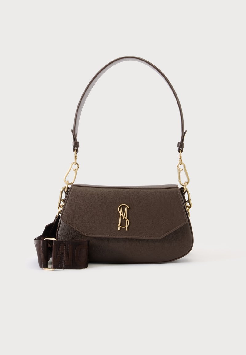 Sac à bandoulière en cuir marron foncé avec logo de fermoir doré et bandoulière large amovible en tissu sur fond clair uni.
