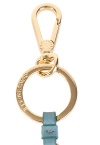 Portachiavi in metallo dorato con clip e anello circolare con logo inciso. È attaccato un cinturino in pelle azzurro chiaro con un rivetto decorativo.