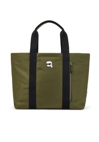 Sac cabas en nylon vert olive avec poignées noires, doté d'une poche latérale zippée et d'un logo argenté en accent. Forme rectangulaire, texture lisse.