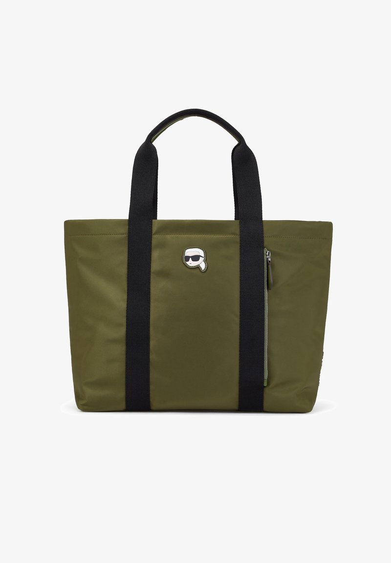 Sac cabas en nylon vert olive avec poignées noires, doté d'une poche latérale zippée et d'un logo argenté en accent. Forme rectangulaire, texture lisse.