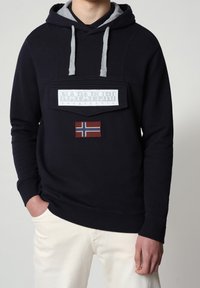 Felpa blu navy con dettagli grigi, caratterizzata da un logo applicato sul davanti e un emblema della bandiera norvegese. Realizzata in morbido tessuto testurizzato con polsini a costine.