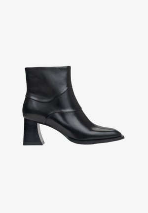 Zwarte leren enkelboot met een spitse neus, een gebogen bovenkant en een unieke blokhak met eencontrasterende zilveren accent.