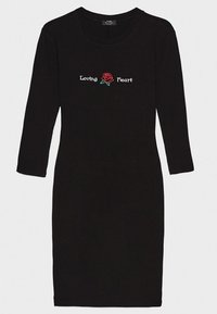 Svart ribbad klänning med trekvartslånga ärmar, prydd med broderad text "Loving Heart" och en röd rosdesign vid bröstet.