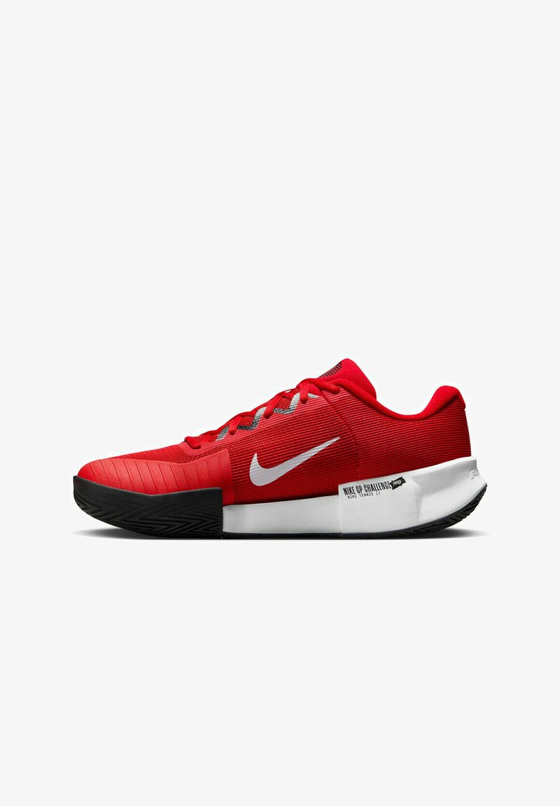 Scarpa da ginnastica rossa con tomaia in mesh testurizzato, logo Nike bianco, suola in gomma nera e un contrafforte prominente etichettato "NIKE GP CHALLENGE."