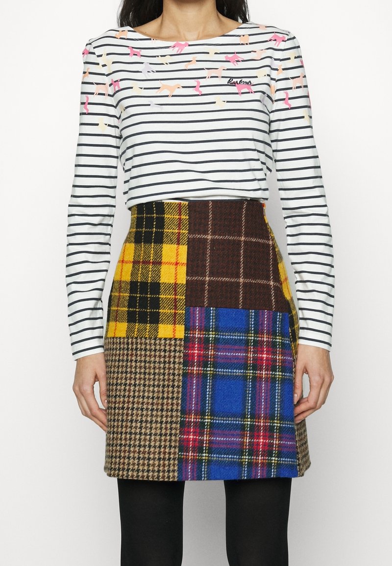 Gestreiftes Langarmshirt mit bunten Tierapplikationen, kombiniert mit einem Patchworkrock, der karierten Mustern in Gelb, Braun, Blau und Plaid zeigt.