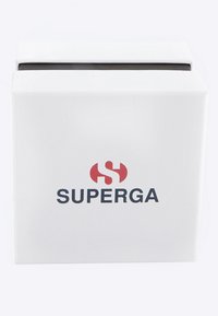 Bela škatla z teksturirano površino, ki na sprednji strani prikazuje rdeči stilizirani logotip "S" in črno besedilo "SUPERGA".