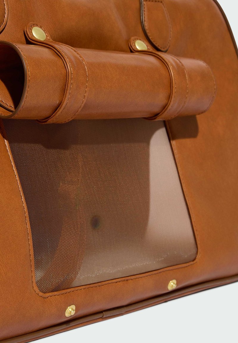 Borsa in pelle marrone con dettagli dorati e finestra in rete per la ventilazione, pensata per trasportare piccoli animali domestici come gatti o cani.