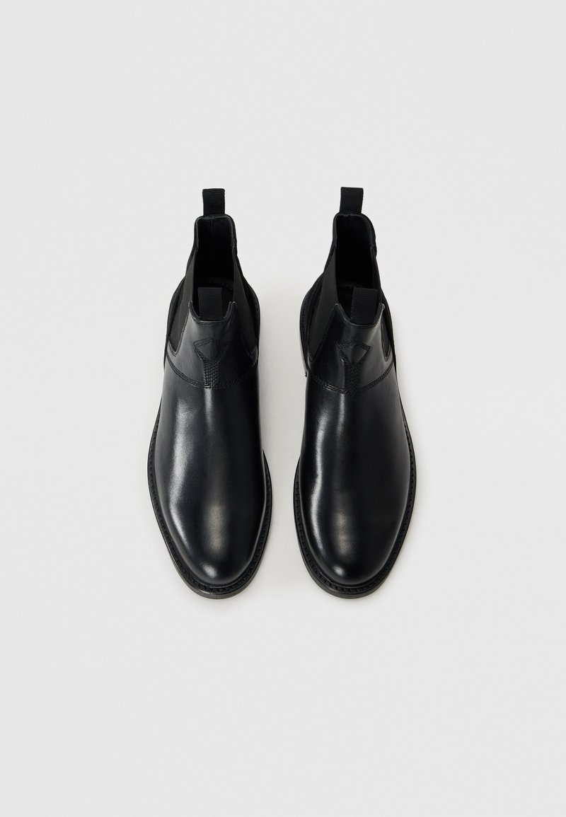 Schwarze Leder-Stiefeletten mit elastischen Seitenpaneelen, glatter Oberfläche, abgerundeter Zehe und Ziehhilfen für ein einfaches Anziehen.