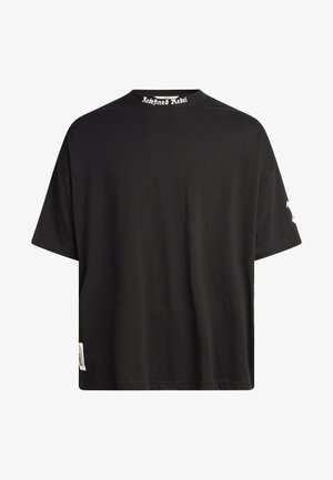 Schwarzes Baumwoll-T-Shirt mit lockerer Passform, kurzen Ärmeln und einem ribbelten Rundhalsausschnitt. Mit "Redefined Rebel"-Text auf dem Kragen.