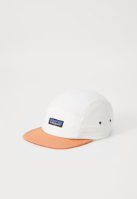 White cotton cap with an orange visor, featuring a Patagonia logo patch in blue and black on the front panel. Two ventilation eyelets visible.