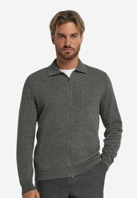 Grauer Reißverschluss-Cardigan aus weichem Strick mit geripptem Saum, Kragen-Design und Brusttasche. Mit langen Ärmeln und einem schlichten, modernen Schnitt.